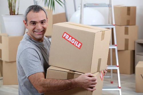 Removal team handling furniture and boxes on a local West London street